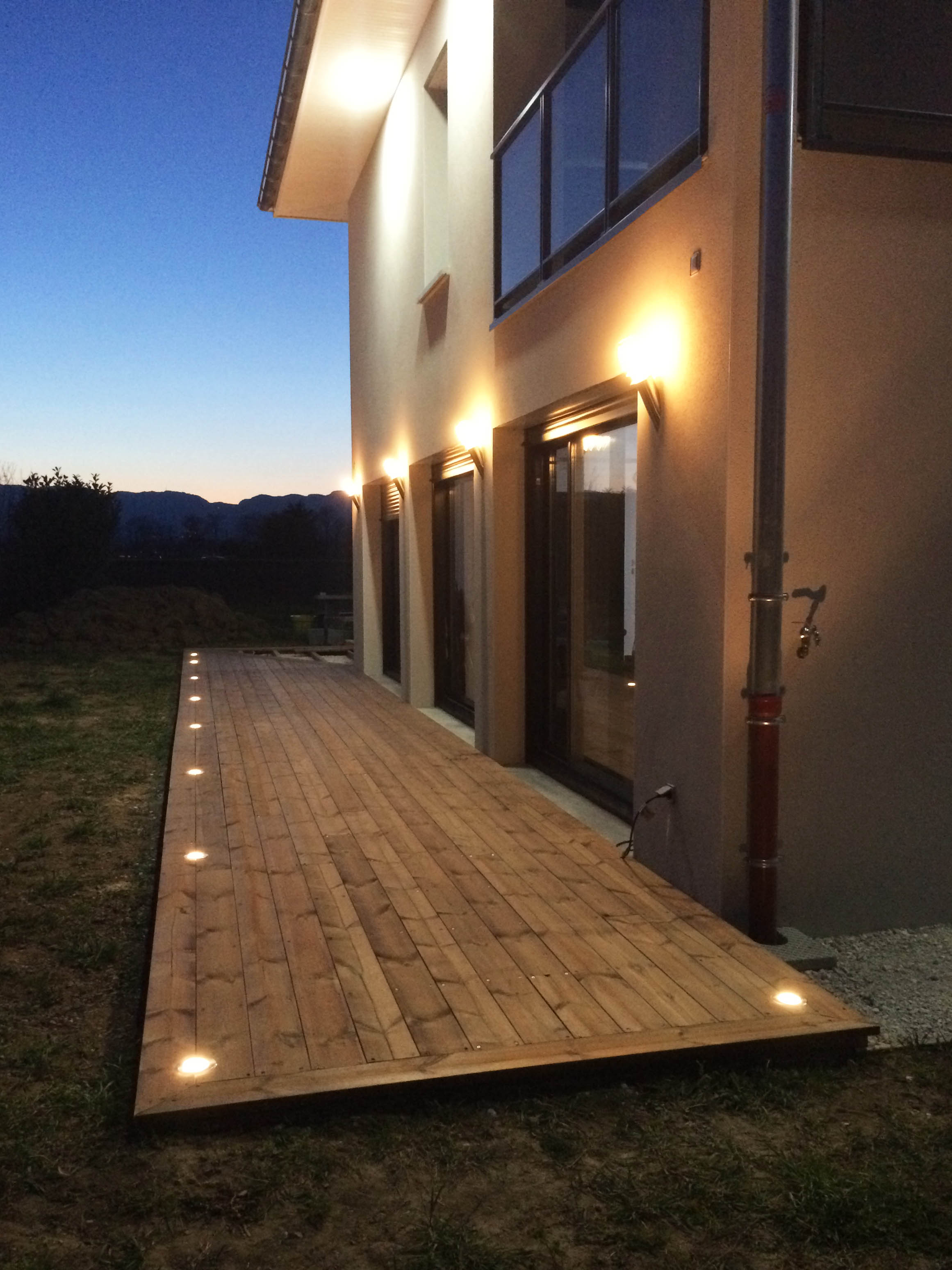 Idée d'éclairage d'une façade de maison et sa terrasse bois